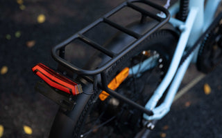 Urban e-bike rider cycling safely at night in the UK with integrated lights and reflective details